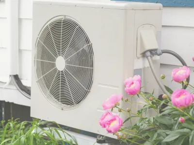 Picture of a heat pump behind some flowers