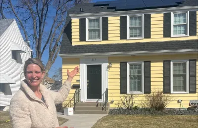 Sarah standing in front of her house