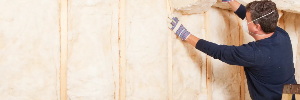 person putting up insulation in their home