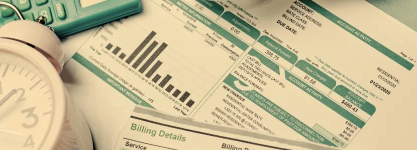 energy bills, covered by a clock, lightbulb, and calculator