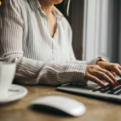 a person typing at their laptop 