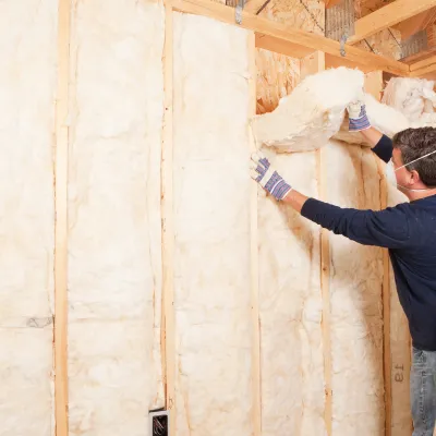 person putting up insulation in their home
